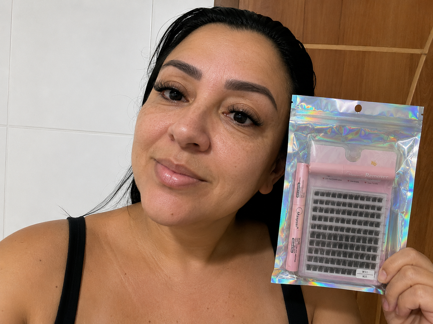 Cliente mostrando o kit cílios em casa com tufos naturais